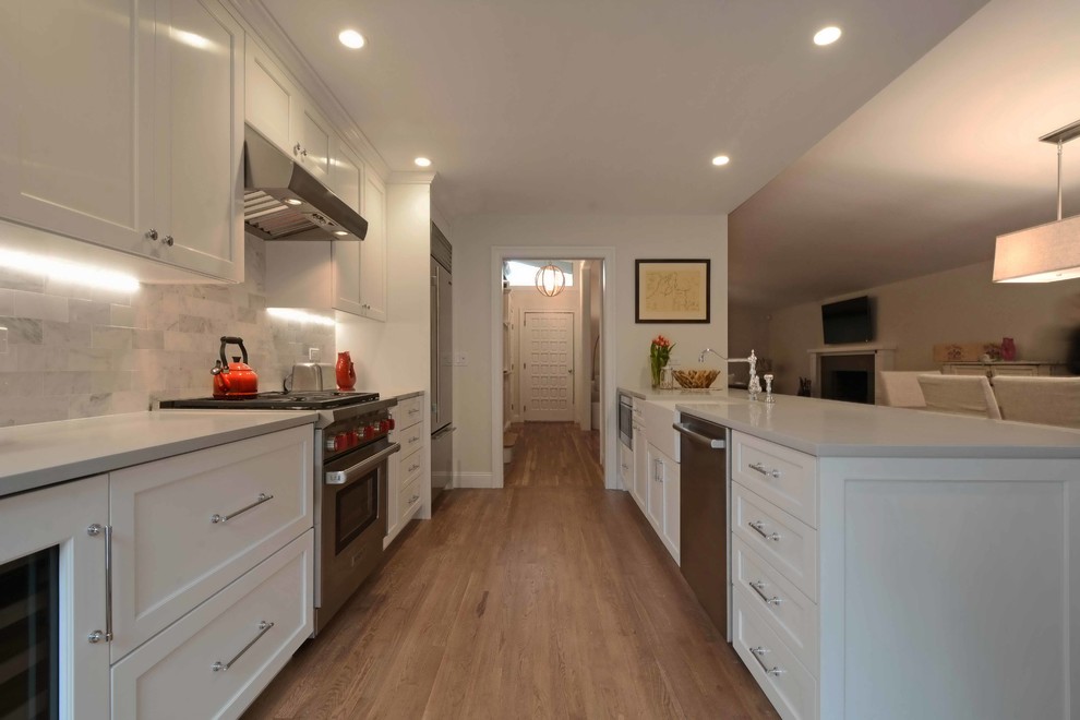 Design ideas for a traditional galley kitchen in New York with a belfast sink, shaker cabinets, stainless steel appliances and medium hardwood flooring.