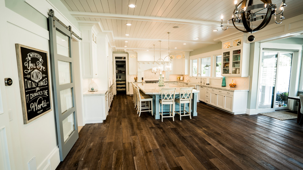 Exempel på ett stort maritimt kök, med skåp i shakerstil, vita skåp, marmorbänkskiva, vitt stänkskydd, en köksö, en rustik diskho, rostfria vitvaror, mörkt trägolv och brunt golv
