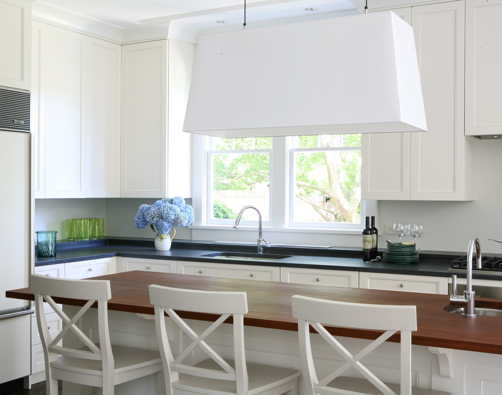 Design ideas for a traditional l-shaped kitchen in New York with a submerged sink, recessed-panel cabinets, white cabinets and integrated appliances.