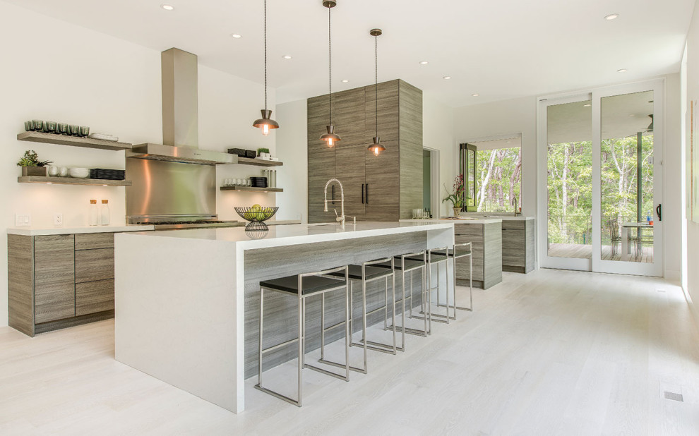 Inspiration for an expansive contemporary l-shaped kitchen/diner in New York with a submerged sink, flat-panel cabinets, medium wood cabinets, engineered stone countertops, stainless steel appliances, ceramic flooring, an island, beige floors and white worktops.
