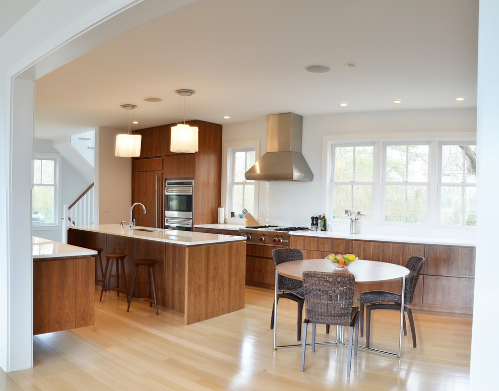 Immagine di una cucina abitabile minimal con ante lisce e ante in legno bruno