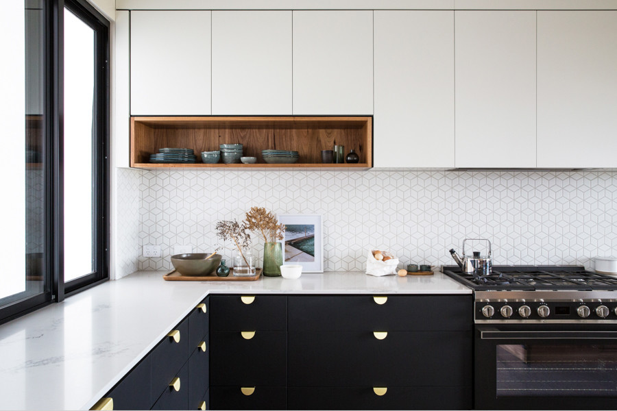 Large urban l-shaped concrete floor and gray floor kitchen pantry photo in Other with a single-bowl sink, flat-panel cabinets, black cabinets, solid surface countertops, white backsplash, ceramic backsplash, black appliances, an island and white countertops