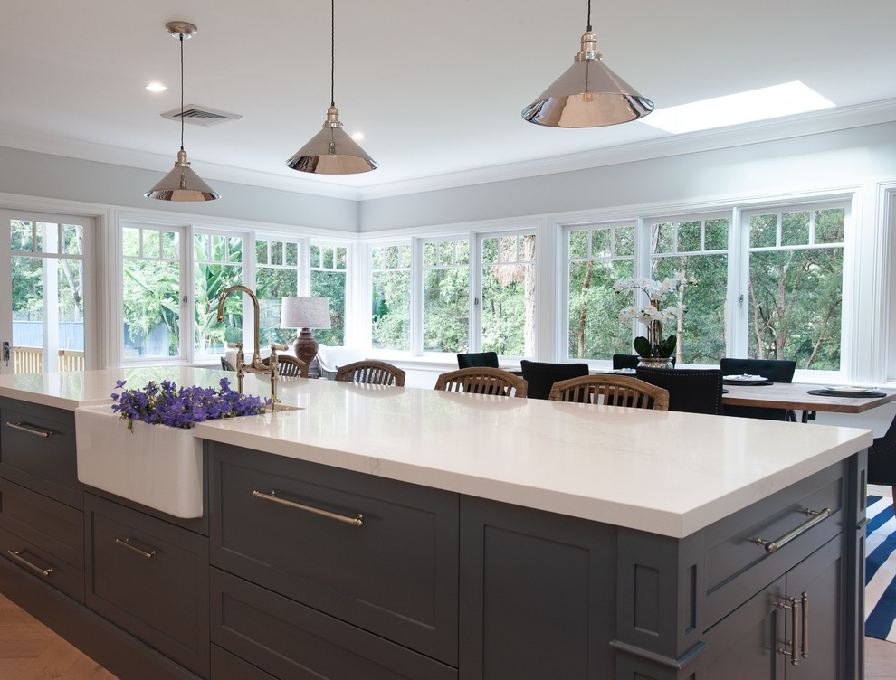 Inspiration for a huge timeless l-shaped light wood floor eat-in kitchen remodel in Sydney with a farmhouse sink, shaker cabinets, white cabinets, quartz countertops, white backsplash, marble backsplash, stainless steel appliances, an island and white countertops