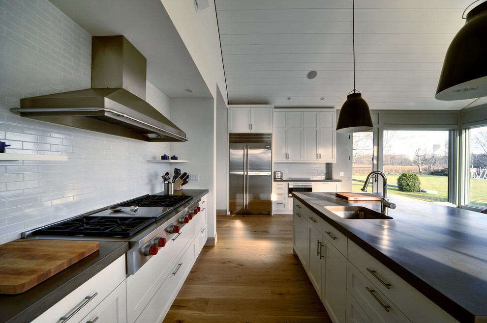 Farmhouse kitchen in New York with stainless steel appliances and concrete worktops.