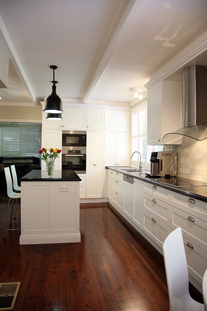 Example of a large transitional galley medium tone wood floor eat-in kitchen design in Sydney with a drop-in sink, shaker cabinets, white cabinets, marble countertops, multicolored backsplash, subway tile backsplash, stainless steel appliances and an island