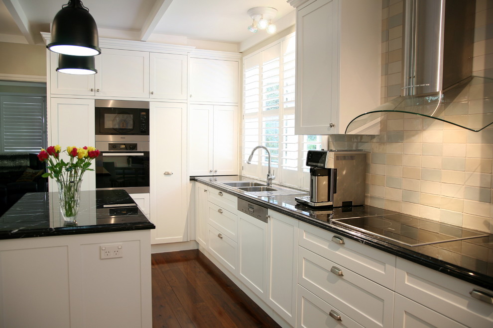 Exempel på ett stort klassiskt kök, med en nedsänkt diskho, skåp i shakerstil, vita skåp, marmorbänkskiva, flerfärgad stänkskydd, stänkskydd i tunnelbanekakel, rostfria vitvaror, mellanmörkt trägolv och en köksö