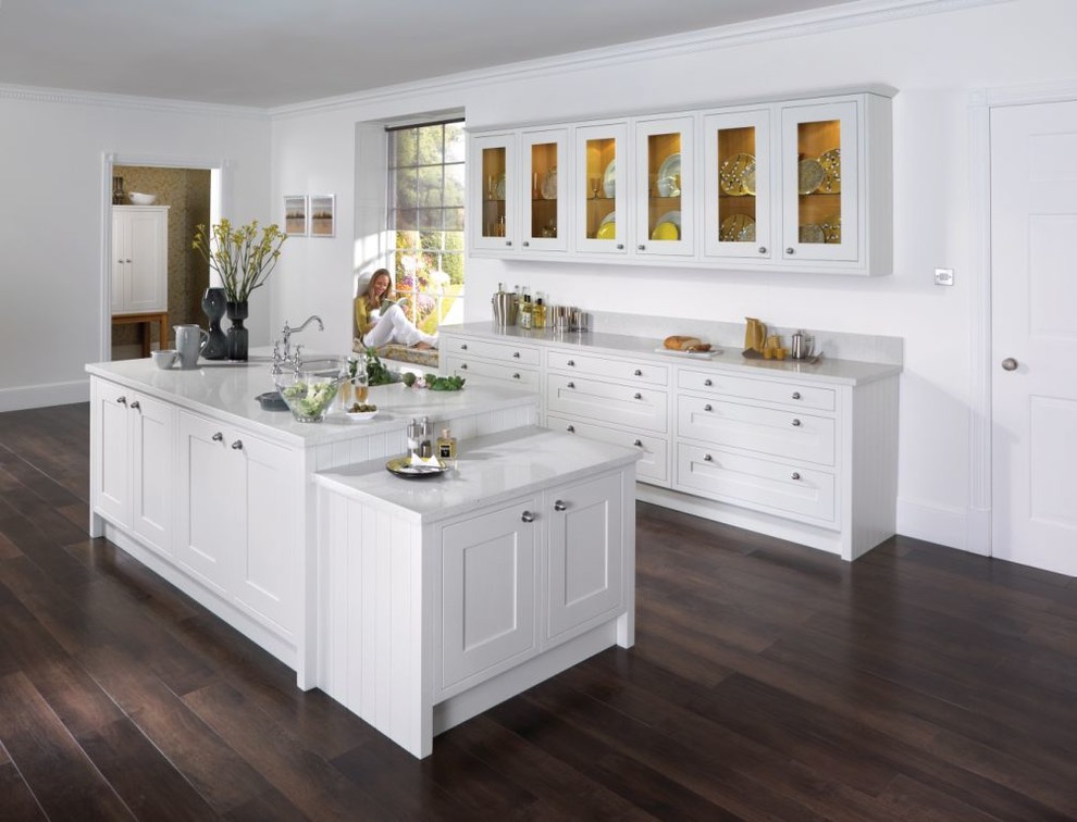 Immagine di una cucina minimal di medie dimensioni con lavello sottopiano, ante in stile shaker, ante bianche, top in quarzo composito, elettrodomestici in acciaio inossidabile, parquet scuro e top bianco
