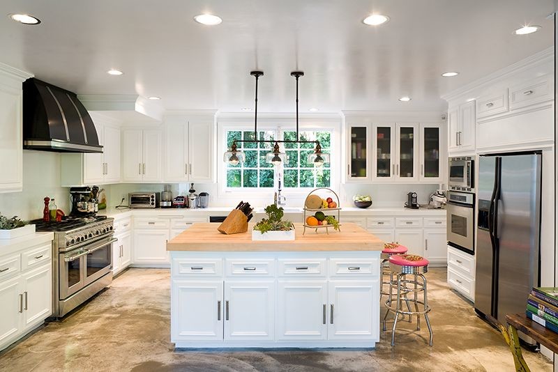 Inspiration for a huge mediterranean concrete floor enclosed kitchen remodel in Los Angeles with flat-panel cabinets, white cabinets and an island