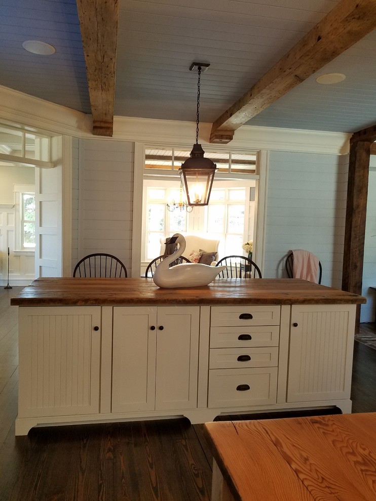 Kitchen - farmhouse medium tone wood floor kitchen idea in Milwaukee with a farmhouse sink, beaded inset cabinets, wood countertops and two islands