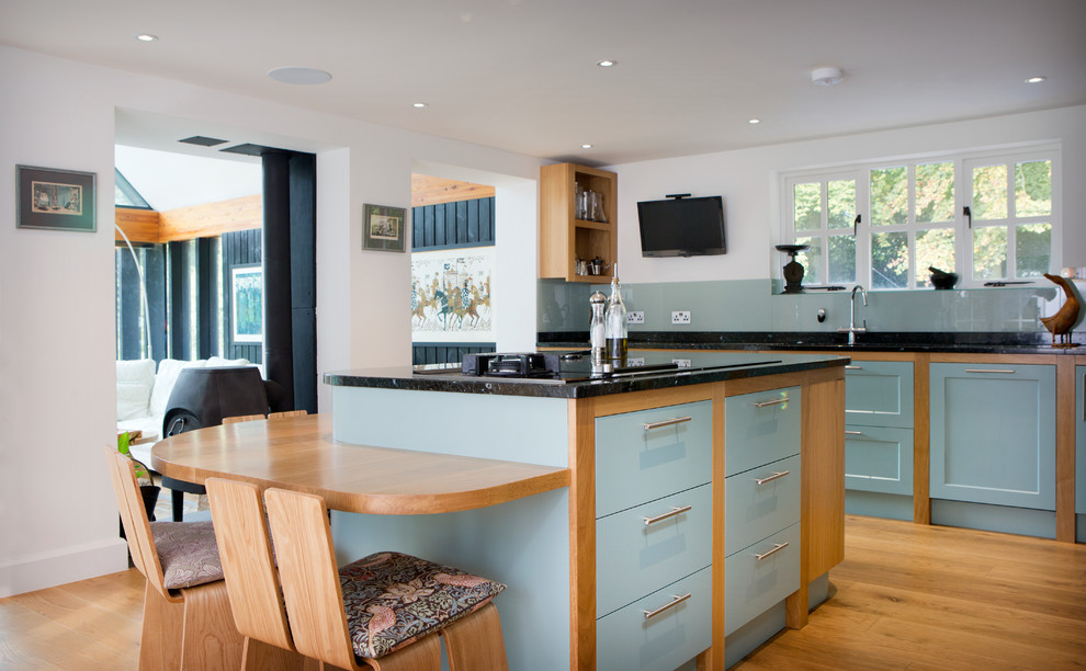 Large classic u-shaped kitchen in Oxfordshire with shaker cabinets, granite worktops, glass sheet splashback and an island.