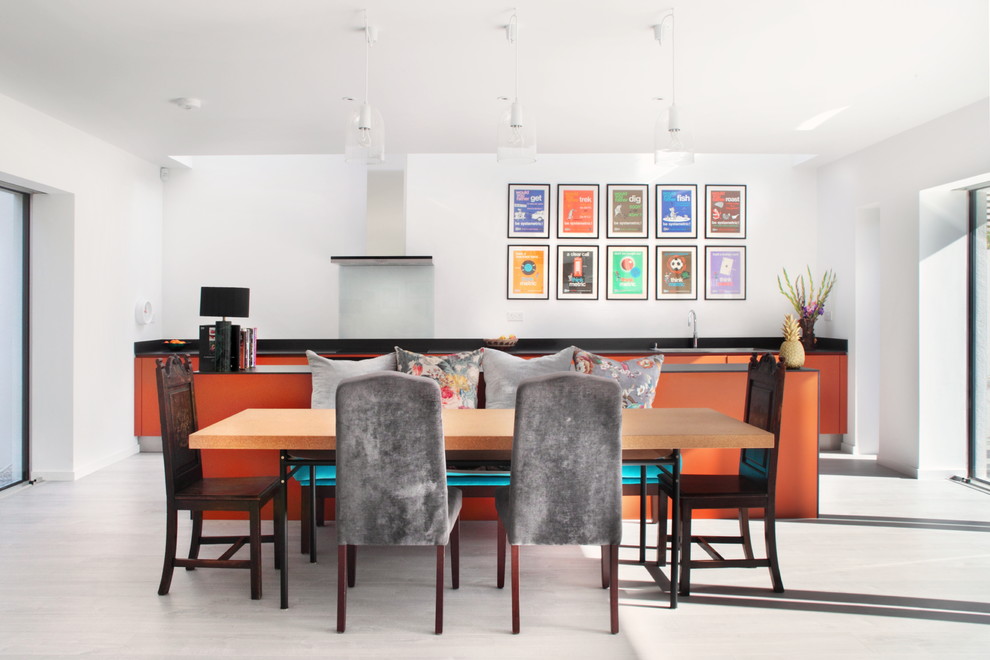 Example of a large trendy galley dark wood floor open concept kitchen design in Hertfordshire with flat-panel cabinets, orange cabinets, blue backsplash, glass sheet backsplash, stainless steel appliances, a drop-in sink, quartzite countertops and an island
