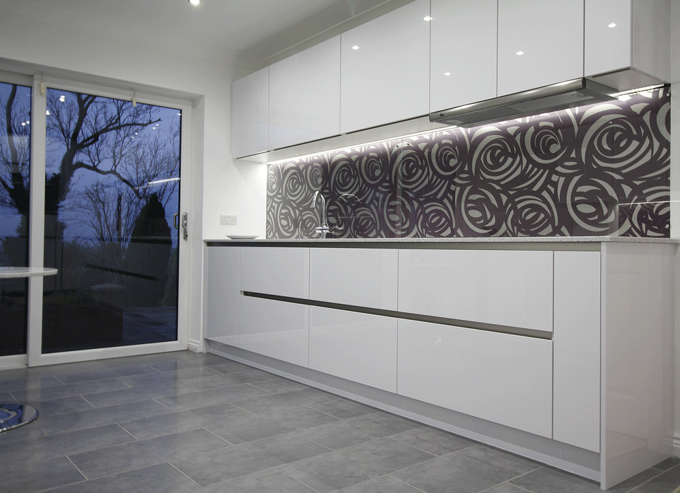 This is an example of a large contemporary kitchen in Other with a submerged sink, flat-panel cabinets, white cabinets, quartz worktops, glass sheet splashback, stainless steel appliances, ceramic flooring and no island.