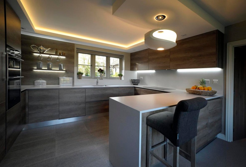 Medium sized contemporary u-shaped kitchen in Essex with flat-panel cabinets, white splashback, dark wood cabinets and a breakfast bar.