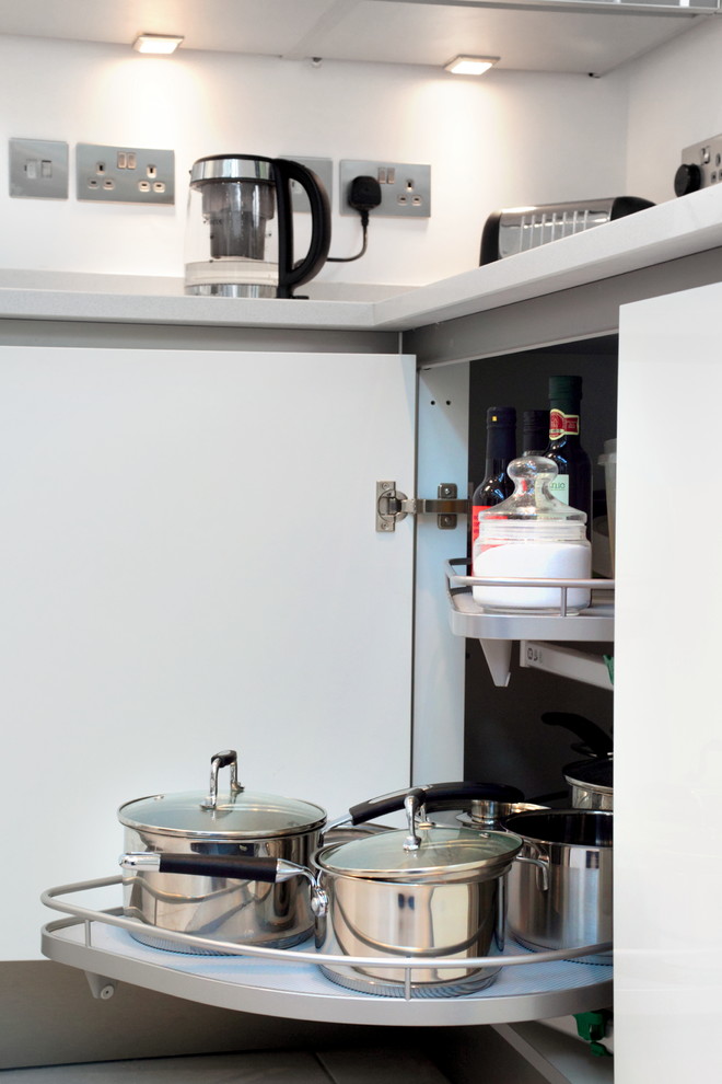 Inspiration för stora moderna kök, med en undermonterad diskho, släta luckor, vita skåp, bänkskiva i kvartsit, rostfria vitvaror, klinkergolv i porslin och en halv köksö