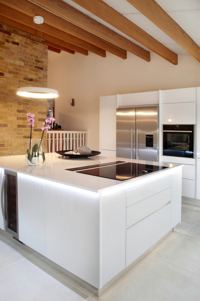 Foto di una grande cucina design con lavello da incasso, ante lisce, ante bianche, top in quarzite, elettrodomestici neri e pavimento in gres porcellanato
