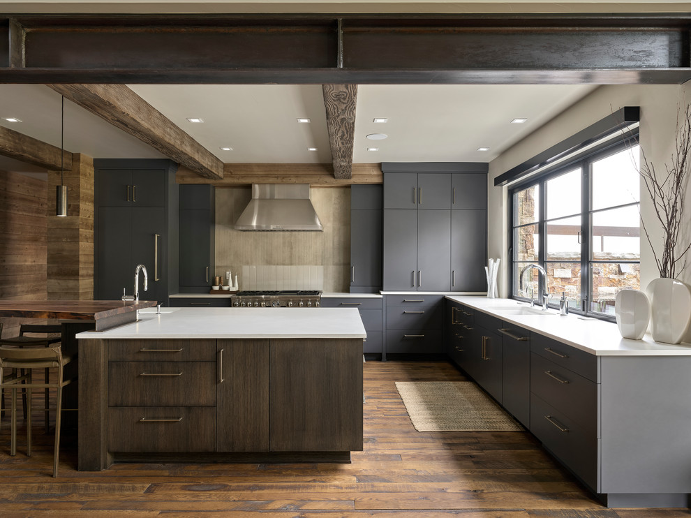 Rustic l-shaped kitchen in Denver with a submerged sink, flat-panel cabinets, grey cabinets, beige splashback, stainless steel appliances, dark hardwood flooring and white worktops.