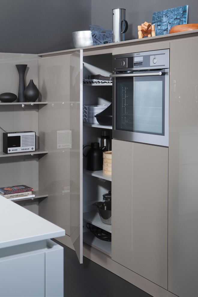 Modelo de cocinas en L moderna de tamaño medio con fregadero de doble seno, armarios con paneles lisos y una isla