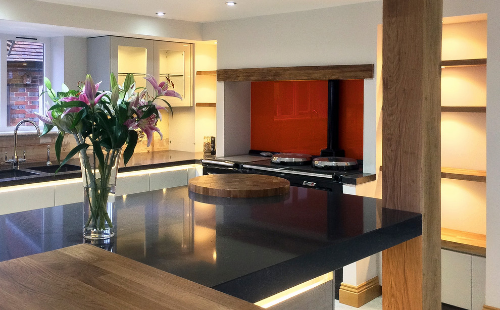 Kitchen - large contemporary kitchen idea in Sussex with quartz countertops, orange backsplash and glass sheet backsplash