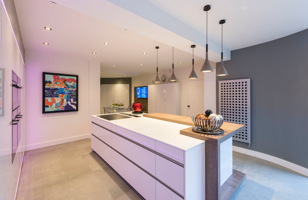 Mittelgroße Moderne Wohnküche in U-Form mit flächenbündigen Schrankfronten, weißen Schränken, schwarzen Elektrogeräten und Kücheninsel in West Midlands