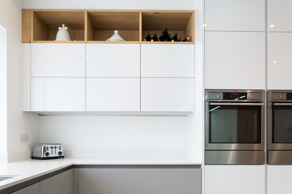 Foto på ett funkis kök och matrum, med släta luckor, bänkskiva i kvartsit och rostfria vitvaror