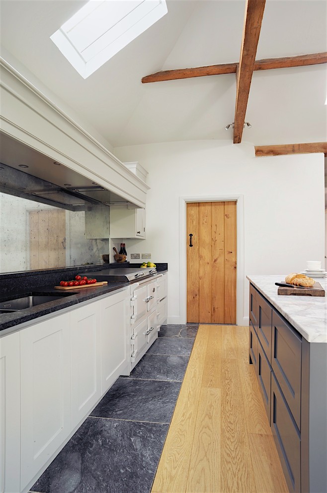 Inspiration för ett stort vintage kök, med luckor med upphöjd panel, grå skåp, granitbänkskiva, stänkskydd med metallisk yta, spegel som stänkskydd och en köksö