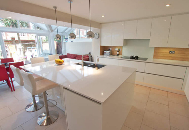Moderne Wohnküche mit weißen Schränken, Quarzit-Arbeitsplatte, Glasfronten und Kücheninsel in London
