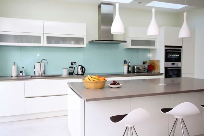 Foto på ett funkis kök, med vita skåp och en köksö