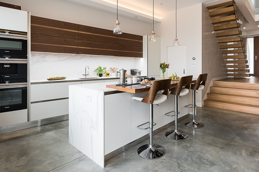 Идея дизайна: прямая кухня-гостиная среднего размера в современном стиле с плоскими фасадами, белыми фасадами, мраморной столешницей, техникой из нержавеющей стали, бетонным полом и островом