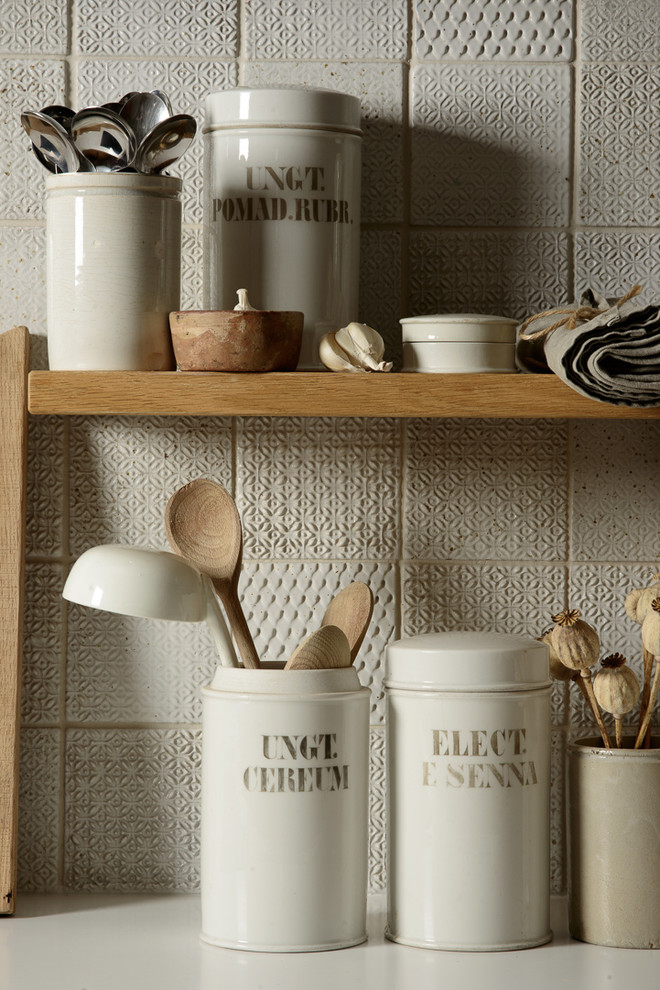 Cette image montre une petite cuisine chalet avec un plan de travail en bois, une crédence blanche et une crédence en céramique.