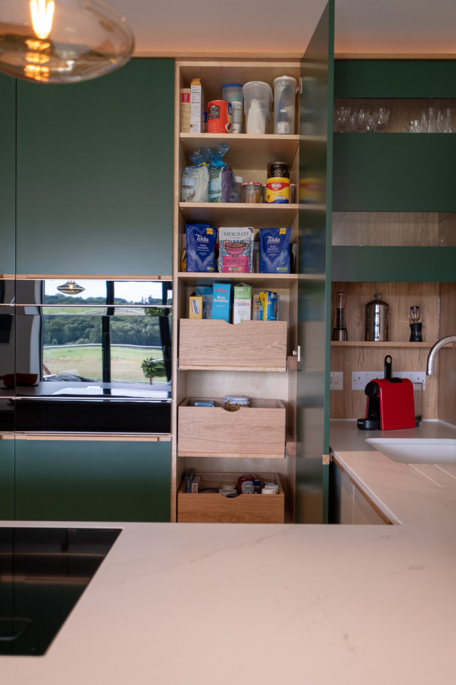 Modern inredning av ett mellanstort kök, med släta luckor, gröna skåp och en halv köksö