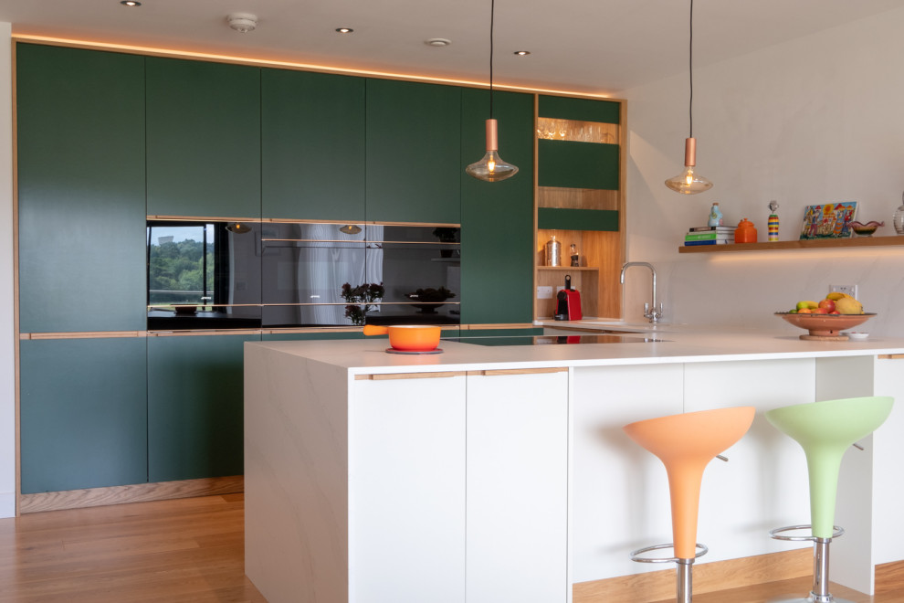 Diseño de cocina actual de tamaño medio con armarios con paneles lisos, puertas de armario verdes y península