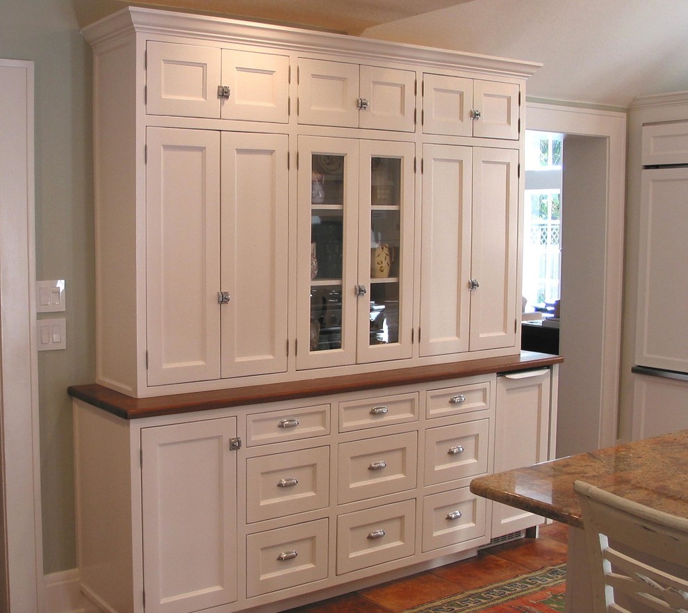 This is an example of a medium sized classic u-shaped enclosed kitchen in Orlando with recessed-panel cabinets, white cabinets, wood worktops, terracotta flooring and an island.