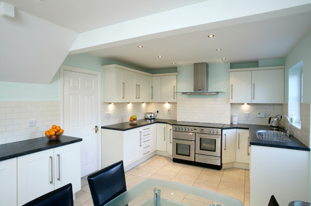 Klassische Wohnküche in U-Form mit flächenbündigen Schrankfronten, weißen Schränken, Küchenrückwand in Weiß und Rückwand aus Metrofliesen in West Midlands