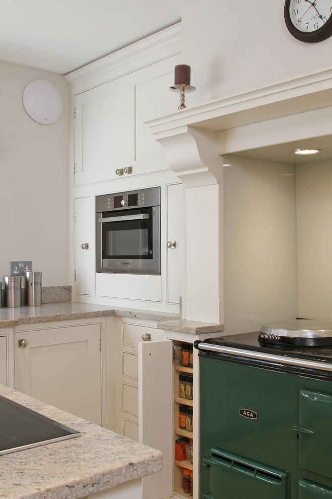 Klassisk inredning av ett stort kök, med en rustik diskho, skåp i shakerstil, vita skåp, granitbänkskiva, kalkstensgolv och en köksö