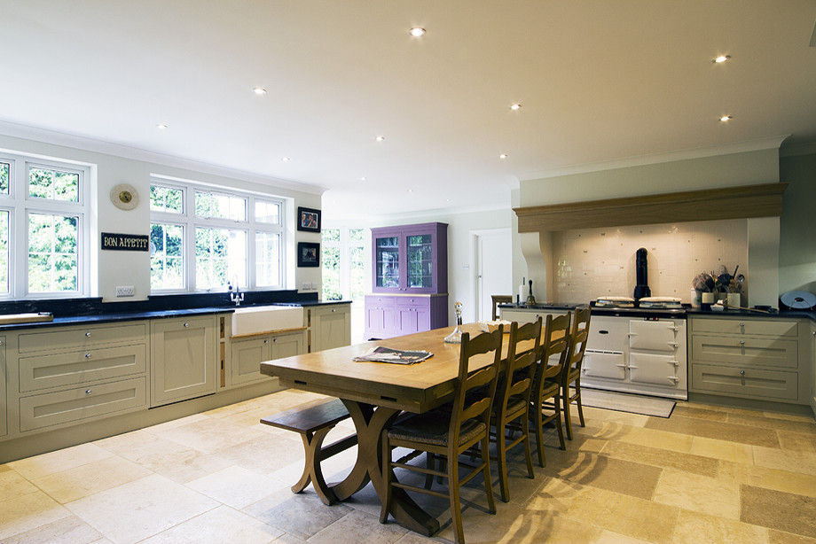 Large traditional l-shaped kitchen/diner in Buckinghamshire with a belfast sink, shaker cabinets, grey cabinets, granite worktops, white splashback, ceramic splashback, stainless steel appliances, limestone flooring and no island.
