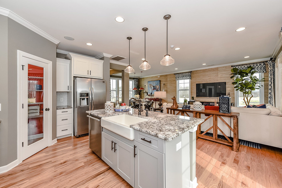 Example of a small farmhouse single-wall light wood floor open concept kitchen design in Charlotte with a farmhouse sink, recessed-panel cabinets, white cabinets, granite countertops, gray backsplash, mosaic tile backsplash, stainless steel appliances and an island