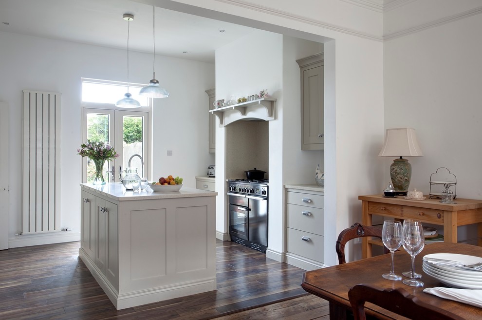 Cette photo montre une cuisine ouverte parallèle tendance avec un placard avec porte à panneau encastré, des portes de placard grises et un électroménager noir.