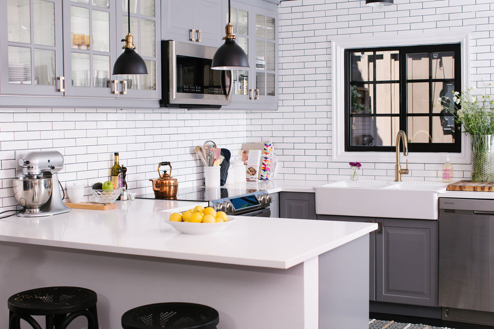 Источник вдохновения для домашнего уюта: кухня в стиле неоклассика (современная классика) с обеденным столом, стеклянными фасадами, серыми фасадами, белым фартуком и техникой из нержавеющей стали