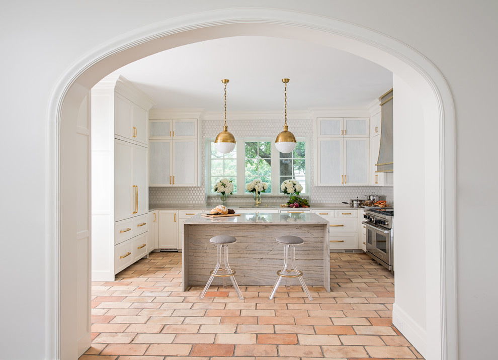 Enclosed kitchen - large transitional u-shaped terra-cotta tile enclosed kitchen idea in Dallas with an undermount sink, shaker cabinets, white cabinets, quartzite countertops, white backsplash, ceramic backsplash, paneled appliances and an island