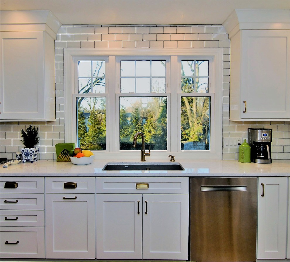 Eat-in kitchen - large cottage l-shaped laminate floor and brown floor eat-in kitchen idea in Philadelphia with an undermount sink, shaker cabinets, white cabinets, quartz countertops, white backsplash, subway tile backsplash, stainless steel appliances and an island