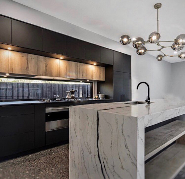 Inspiration for a mid-sized modern galley concrete floor and brown floor eat-in kitchen remodel in Sunshine Coast with an undermount sink, beaded inset cabinets, black cabinets, quartz countertops, window backsplash, black appliances, an island and black countertops