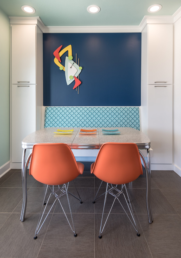 Пример оригинального дизайна: кухня в стиле фьюжн с обеденным столом, плоскими фасадами, синим фартуком и белыми фасадами