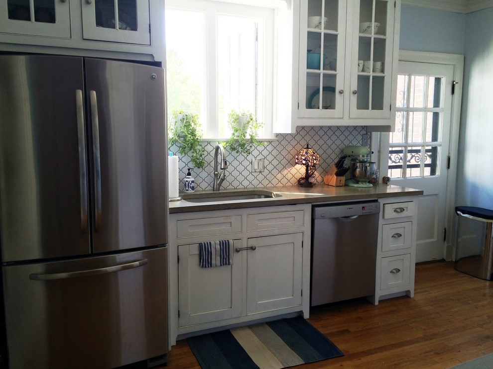 Exempel på ett modernt kök och matrum, med en undermonterad diskho, skåp i shakerstil, vita skåp, bänkskiva i kvartsit, vitt stänkskydd, stänkskydd i porslinskakel, rostfria vitvaror och mellanmörkt trägolv