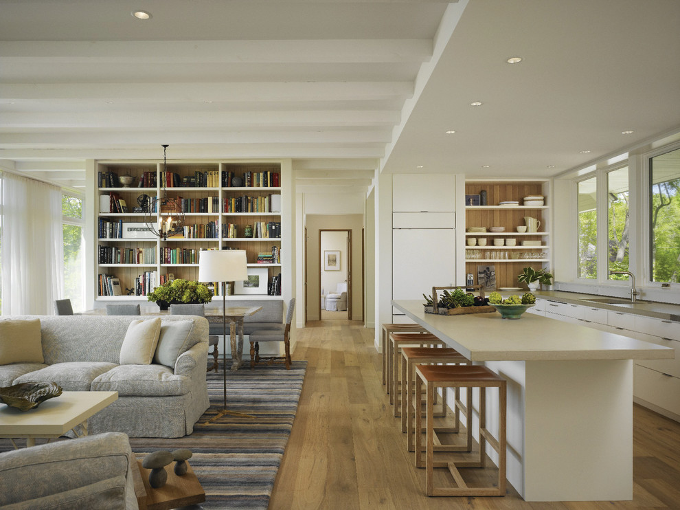 Large classic grey and cream l-shaped open plan kitchen in Other with medium hardwood flooring, a submerged sink, flat-panel cabinets, white cabinets, integrated appliances, an island and engineered stone countertops.