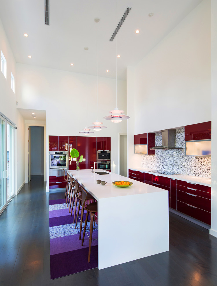 Inspiration for a contemporary l-shaped kitchen in Miami with flat-panel cabinets, red cabinets and mosaic tiled splashback.
