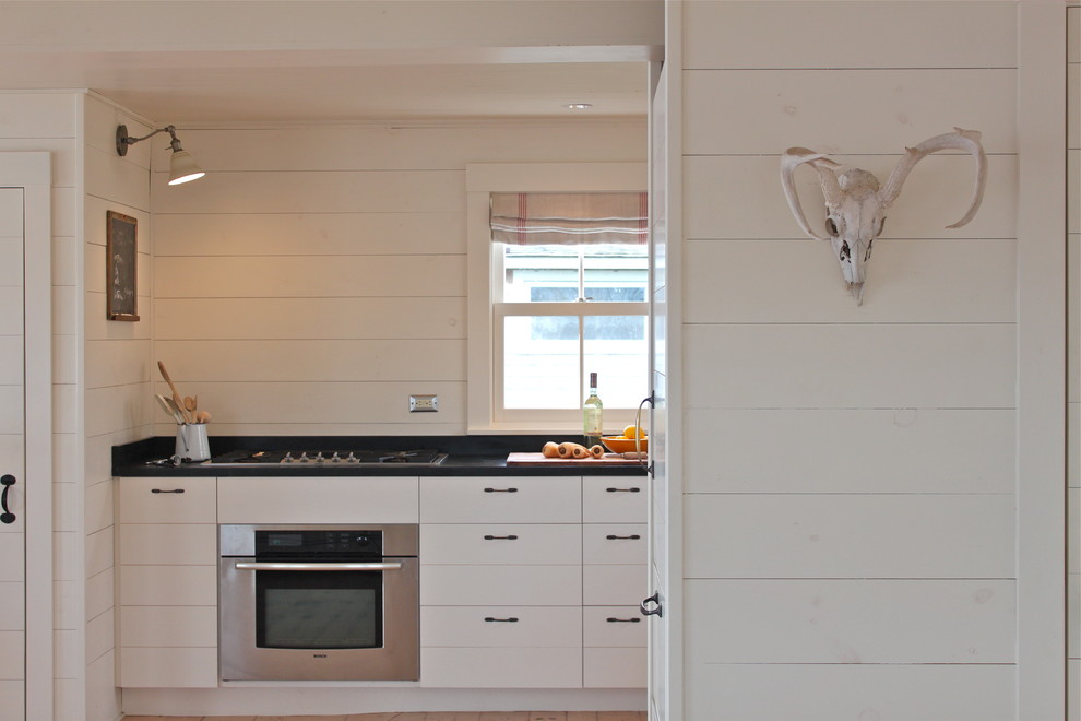 Ejemplo de cocina rústica con electrodomésticos de acero inoxidable y cortinas