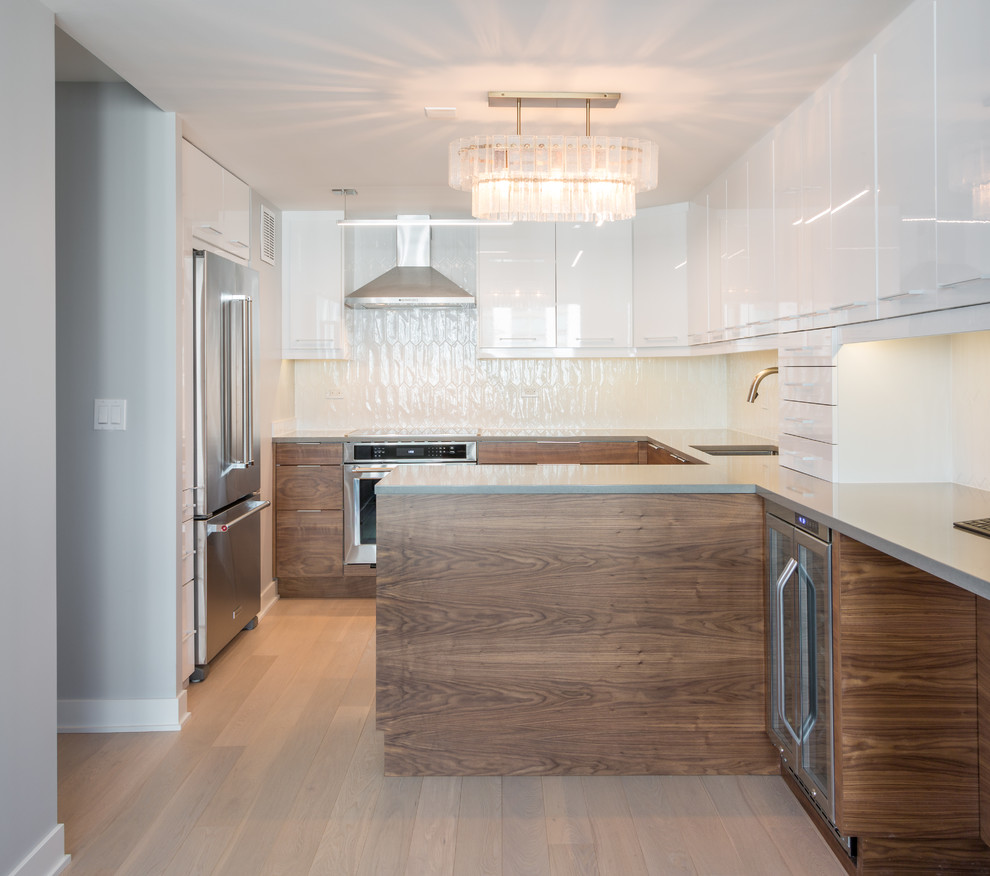 Mid-sized trendy u-shaped light wood floor open concept kitchen photo in Chicago with an undermount sink, flat-panel cabinets, dark wood cabinets, quartz countertops, white backsplash, ceramic backsplash, stainless steel appliances and a peninsula