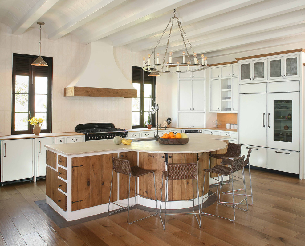 Immagine di un'ampia cucina a L stile marinaro con ante lisce, ante bianche, paraspruzzi bianco, elettrodomestici da incasso e pavimento in legno massello medio