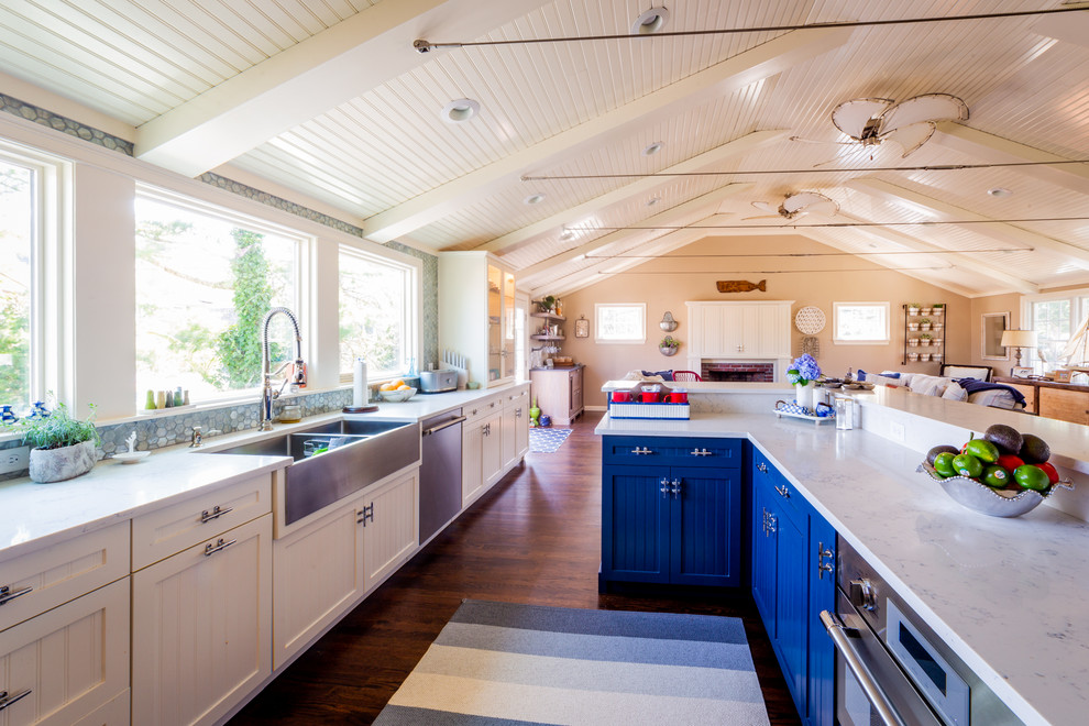 Foto på ett mellanstort funkis vit kök, med en rustik diskho, luckor med infälld panel, vita skåp, träbänkskiva, grönt stänkskydd, stänkskydd i glaskakel, rostfria vitvaror, mellanmörkt trägolv, en köksö och brunt golv