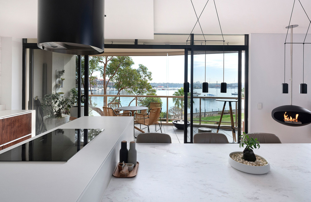 This is an example of a small modern single-wall kitchen/diner in Sydney with a submerged sink, flat-panel cabinets, medium wood cabinets, marble worktops, white splashback, marble splashback, light hardwood flooring, an island, beige floors and white worktops.